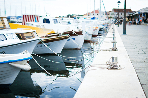 A row of sailboats docked at a boat marina.