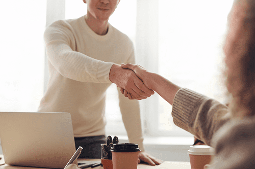 A business meeting between two professionals shaking hands.