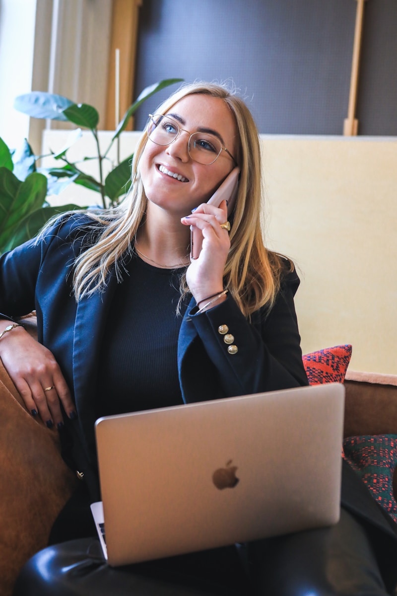 woman with High Net Worth Insurance in blue long sleeve shirt sitting on brown couch